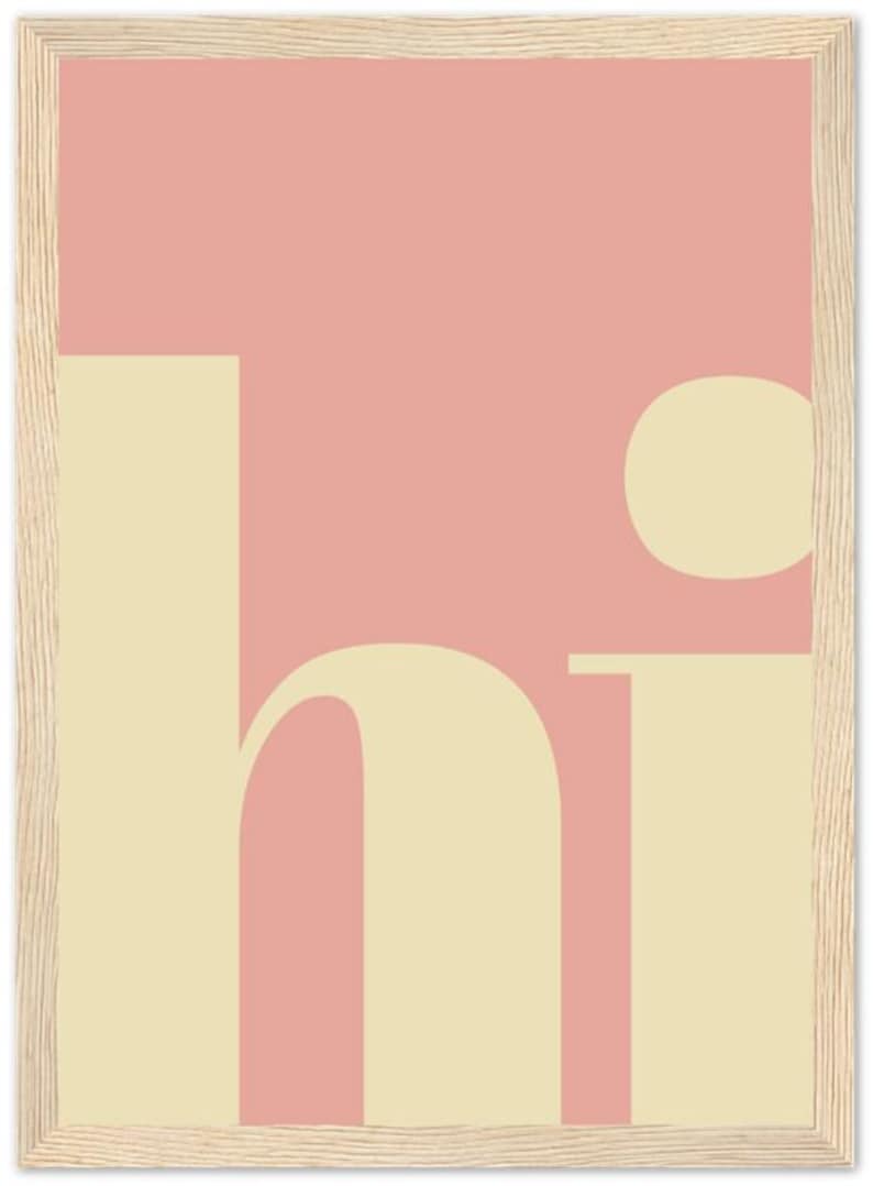 May include: A framed art print with a minimalist design. The artwork features the word "hi" in a soft, cream-colored font against a pink background. The frame is made of light-colored wood, adding a natural touch.