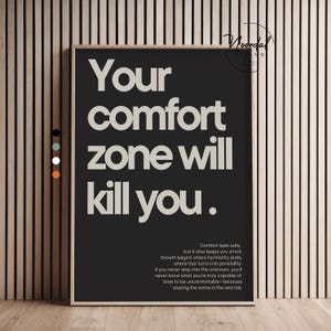 Könnte beinhalten: Ein gerahmter Schwarz-Weiß-Druck mit dem Text "Your comfort zone will kill you." Der Druck enthält auch einen kleineren Textabsatz. Der Rahmen ist hellbraun.