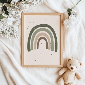 Puede incluir: Una impresión artística enmarcada con un diseño de arcoíris en tonos verdes, beige y marrón. La obra de arte está sobre un fondo beige claro y enmarcada en un marco de madera clara. Un osito de peluche y flores blancas están en la imagen.