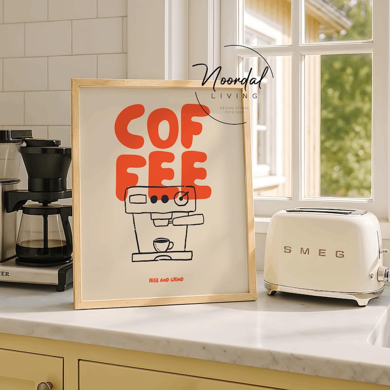 May include: A framed art print with the word "COFFEE" in red block letters and a black line drawing of a coffee machine. The phrase "RISE AND GRIND" is below the drawing. A cream-colored toaster is to the right.