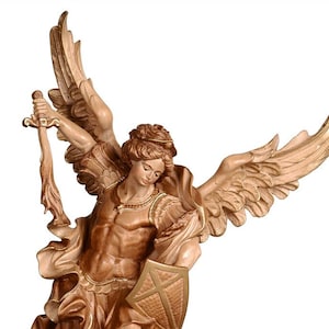 Può includere: Una statua in legno dell'Arcangelo Michele, un angelo guerriero, in piedi su un demone. L'angelo è raffigurato con ali, una spada e uno scudo. Il demone è sdraiato sulla schiena, con la testa girata di lato. La statua è dipinta in tonalità di marrone e oro.