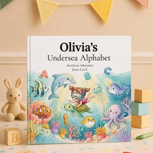 May include: A hardcover children's book titled Olivia's Undersea Alphabet: An Ocean Adventure from A to Z. The cover features a colorful watercolor illustration of a child snorkeling on a sea turtle surrounded by various sea creatures.