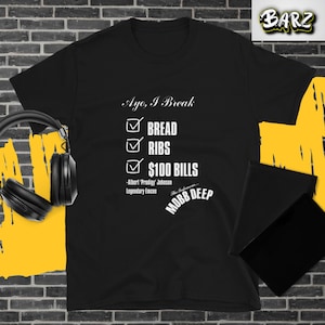 May include: Black t-shirt with white text that reads "Ayo, I Break" and a checklist with the items "Bread", "Ribs", and "$100 Bills" checked off. Below the checklist is the text "Albert 'Prodigy' Johnson Legendary Emcee" and "The Infamous... MOBB DEEP".