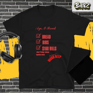 May include: Black t-shirt with red text that reads "Ayo, I Break" followed by a checklist of "BREAD", "RIBS", and "$100 BILLS". The shirt also includes the text "-Albert 'Prodigy' Johnson Legendary Emcee" and "MOBB DEEP".