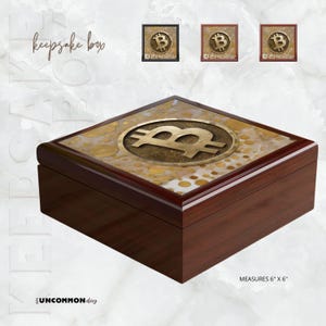 May include: A dark wood keepsake box with a Bitcoin symbol on the lid. The lid is 6" x 6" and features a gold-colored Bitcoin symbol on a decorative surface with gold accents. The box has a polished finish.