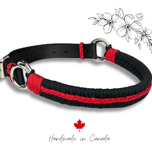Op de afbeelding: Zwarte en rode hondenhalsband met een metalen sluiting en D-ring. De halsband is gemaakt van zwart geweven materiaal met een rode accent. De tekst "Handmade in Canada" staat onderaan de afbeelding.