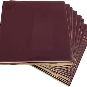 May include: A stack of ten burgundy ceramic tiles. The tiles are square and have a glossy finish.