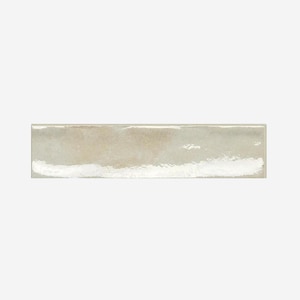 May include: A rectangular, light beige ceramic tile with a glossy finish. The tile has a slightly uneven surface and a white, textured edge. The tile is approximately 12 inches long.