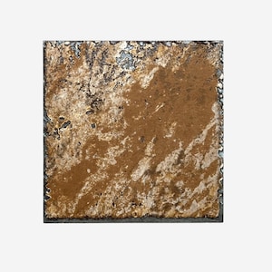May include: Square, textured art piece with a brown and gold color scheme. The artwork has a rough, uneven surface with dark edges. The piece appears to be made of a composite material, possibly metal or stone, and is set against a white background.