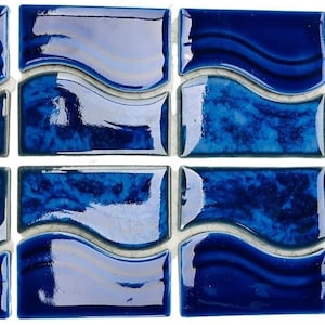 May include: A set of ten blue ceramic tiles with a wavy design. The tiles are glossy and have a light blue and white marbled effect.