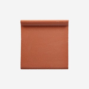 May include: A square, terracotta-colored tile with a rounded edge. The tile has a textured surface and a uniform color. The design is simple and modern, suitable for various interior design projects.