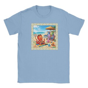 Peut inclure: T-shirt bleu clair avec une scène de plage colorée. L'illustration montre des pieuvres de dessin animé à la plage, dont une mangeant des gaufres. D'autres pieuvres se détendent sous un parasol. Le texte sur le panneau indique "Waffles & Paradise".