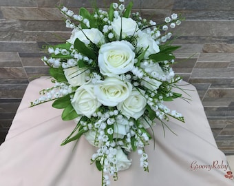May include: A cascading bridal bouquet with white roses and lily of the valley.