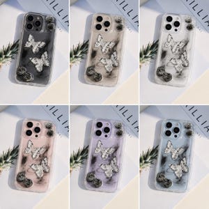 May include: Six phone cases with butterfly and rose designs. Each case has a clear background with a marble effect and silver butterflies. The cases are available in black, beige, white, pink, purple, and blue.