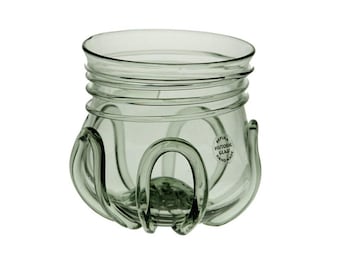 May include: A clear glass jar with a unique design. The jar has a wide opening, a ridged neck, and curved handles. The jar has a label that reads "REPLICA HISTORIC GLAU HANDMADE".