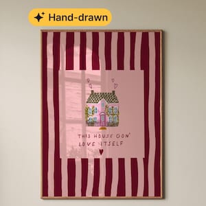 May include: Hand-drawn art print featuring a pink house illustration with a heart above the chimney and the text "THIS HOUSE GON' LOVE ITSELF". The artwork is set against a pink background with vertical burgundy stripes.