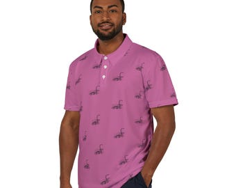 May include: A pink short-sleeved polo shirt with a repeating pattern of black Loch Ness monsters. The shirt has a button-up collar and a three-button placket.