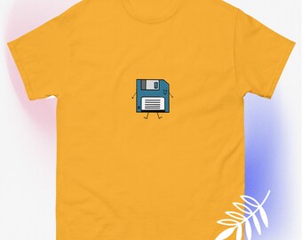 May include: Mustard yellow t-shirt featuring a cartoon floppy disk character. The blue floppy disk has a smiling face, arms, and legs. The shirt is a classic crew neck style.