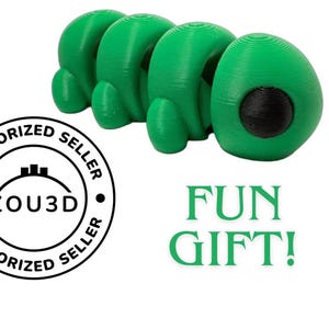 Puede incluir: Un juguete verde brillante segmentado, que se asemeja a una oruga. El juguete tiene una serie de secciones redondeadas con un detalle circular negro en el extremo. Las palabras "FUN GIFT!" están en texto verde. También hay un logotipo circular con "ZOU3D".