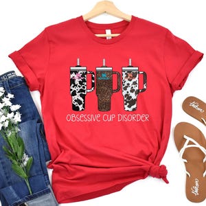 a red shirt with two cups of coffee on it