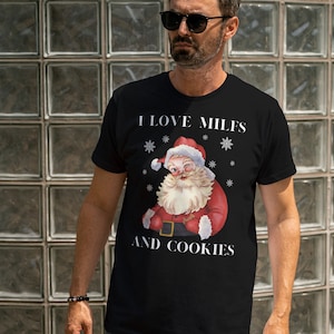 May include: A black t-shirt with a white graphic of Santa Claus with the text "I love MILFS and cookies".
