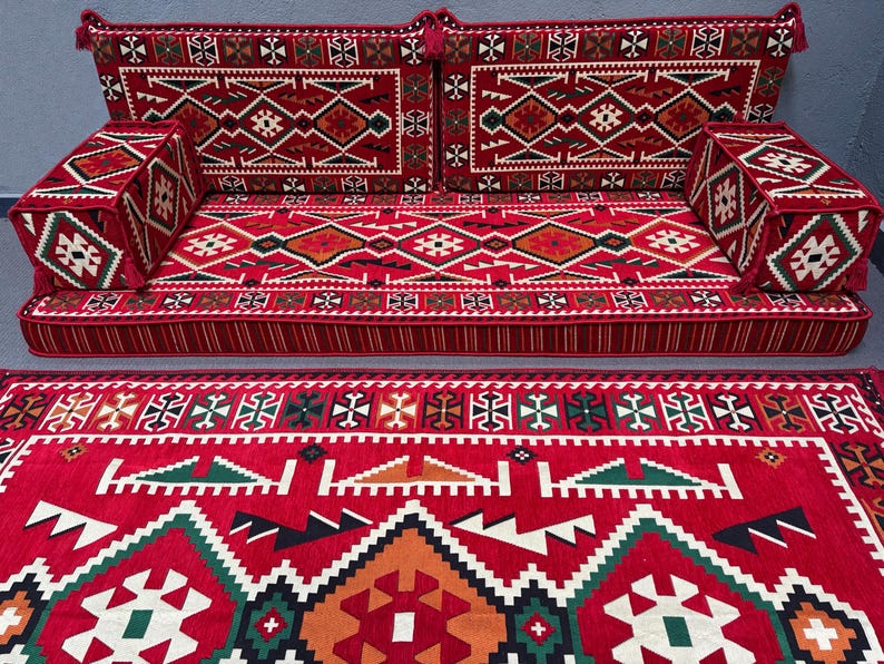 May include: A red and green patterned floor cushion set with a matching rug. The cushions are made of a soft, plush fabric and are perfect for lounging or sitting on the floor. The rug is made of a durable material and is easy to clean.