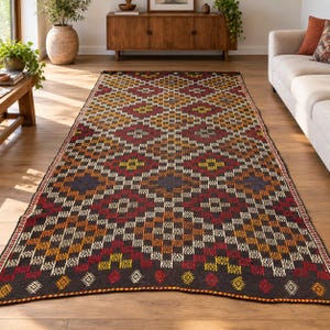 May include: A rectangular area rug featuring a dark brown base with a repeating geometric diamond pattern in shades of red, orange, yellow, and blue. The design consists of small checkered squares and intricate white linear motifs throughout.