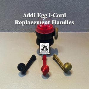 May include: Three replacement handles for an Addi Egg i-Cord knitting machine. The handles are black, red, and gold.