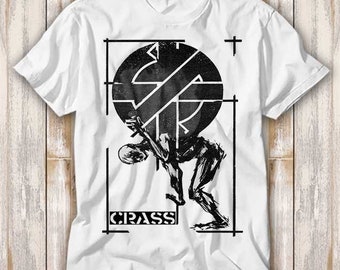 May include: White t-shirt with a black and white graphic print of a figure holding a circle with a symbol inside. The text "CRASS" is printed below the figure.