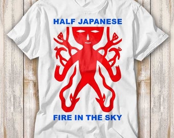 May include: White t-shirt with a red graphic of a stylized figure with the text "HALF JAPANESE FIRE IN THE SKY" in blue.