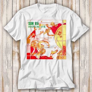 Op de afbeelding: Wit T-shirt met een grafische print van een gele, oranje en rode albumhoes. De albumhoes toont de tekst "Sun Ra Discipline 27-II".