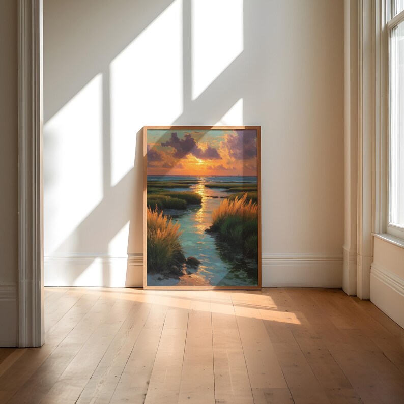 a large, framed painting of a serene landscape with a river and a sunset in the background, set against a white wall and wooden floor.