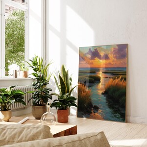 a living room with a large painting of a sunset landscape hanging on the wall, surrounded by potted plants and a wooden coffee table.