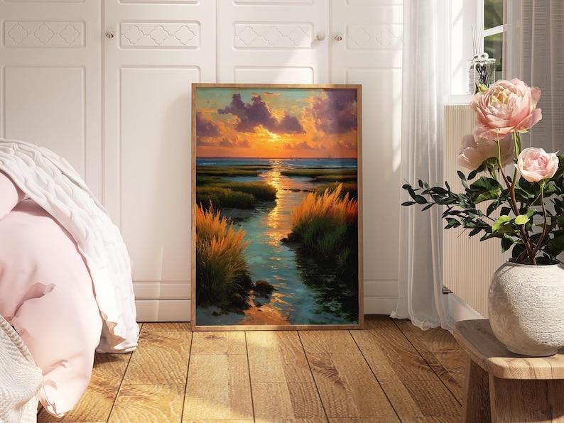 a large framed painting of a serene landscape with a river, grass, and a sunset sky, displayed in a room with white walls and a wooden floor.