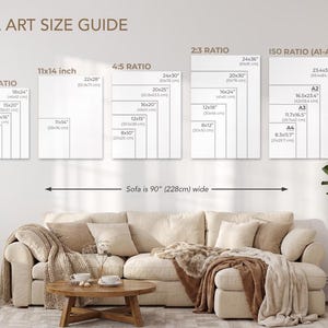 a wall art size guide for various sofa sizes, with a cozy living room setting featuring a beige sofa, a coffee table, and a potted plant.