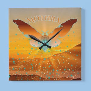 May include: Square wall clock featuring a stylized illustration of a moth with the word "MOTHRA" above it. The clock face has a sunset-like background with orange, yellow, and blue accents. Black clock hands indicate the time.