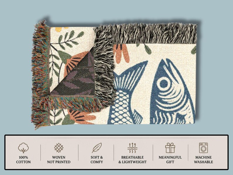 May include: Woven cotton throw blanket with a fish and floral design. The blanket features a cream background with blue fish and orange and green floral accents. The edges have a fringed trim. The blanket is machine washable.