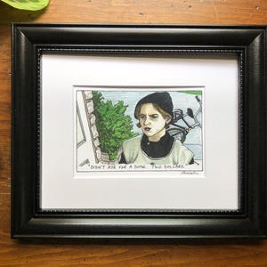 Op de afbeelding: Een handgetekende illustratie van een jong persoon die een zwarte beanie en een lichtgrijze jas draagt. De persoon kijkt de kijker recht aan met een serieuze uitdrukking. De achtergrond is een groene struik en een bakstenen muur. De tekst "Didn't ask for a dime, two dollars." staat onder de afbeelding.