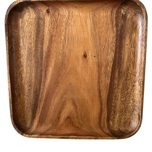 Puede incluir: Bandeja cuadrada de madera para servir con esquinas redondeadas. La bandeja está hecha de madera de color marrón claro con un patrón de vetas visible. La bandeja está vacía y lista para servir alimentos o exhibir artículos.