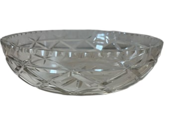 May include: A clear, oval glass bowl featuring a diamond-cut design. The bowl has a gently scalloped edge and is crafted to reflect light, producing a shimmering effect. This decorative bowl is suitable for serving or display, measuring approximately 25 cm in diameter.