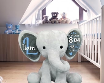 May include: Gray plush elephant stuffed animal with blue and gray ears. The ears have personalized details, including the name "Liam", the date "11-04-2022", the time "3:15 PM", the weight "8 oz", and the length "12 in".