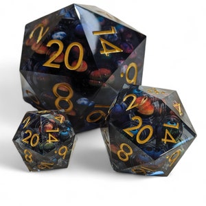 May include: Three black and blue dice with gold numbers. The dice are translucent and have a galaxy-like pattern. The numbers on the dice are 20, 14, 8, 9, 6, and 1.