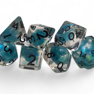 May include: A set of seven clear, multi-sided dice with black numbers and a swirling blue and white interior. The dice are arranged in a pile, with various faces visible, including a four-sided die and a twenty-sided die. The dice are for tabletop games.