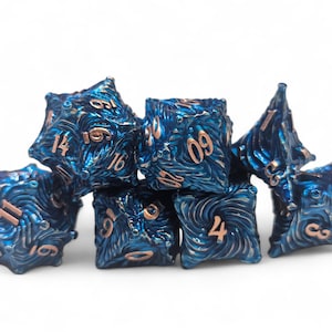 Könnte beinhalten: Ein Satz von sieben blauen und kupfernen Würfeln mit einem wirbelnden Muster. Die Würfel sind mit den Zahlen 1 bis 6 und 11, 14, 16, 4, 9 beschriftet.