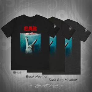 May include: Black, black heather, and dark gray heather t-shirts with a graphic of a prehistoric sea creature with the word "GAR" in red letters above it.