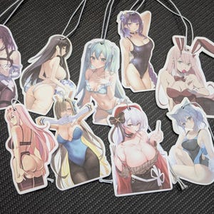 May include: A collection of anime-style air fresheners featuring various female characters in swimsuits and lingerie. Each air freshener is a unique design with a string for hanging. The color palette includes shades of pink, blue, and black.