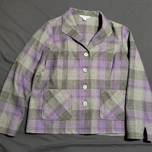 May include: A gray and purple plaid blazer with three white buttons and two front pockets. The blazer has a classic collar and a tailored fit. The fabric appears to be a wool blend. The brand name "Pendleton" is visible on the label.