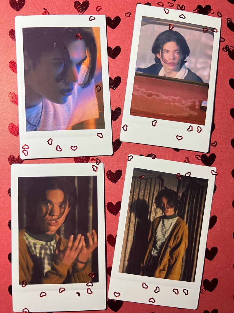 May include: Four Polaroid photos of a young person with dark hair. The photos are arranged in a grid pattern on a red background with red glitter hearts. The photos show the person in different poses and settings.