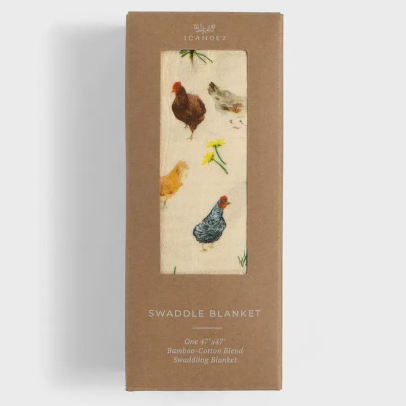 May include: A swaddle blanket in a cardboard box. The blanket features a cream background with colorful illustrations of chickens and flowers. The box reads "SWADDLE BLANKET" and "One 47"x47" Bamboo-Cotton Blend Swaddling Blanket."