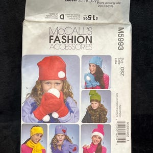 May include: A McCall's M5993 fashion accessories sewing pattern envelope featuring illustrations of various hats, scarves, and mittens in colors including red, blue, green, yellow, and purple, with text labels for sizes and item numbers.